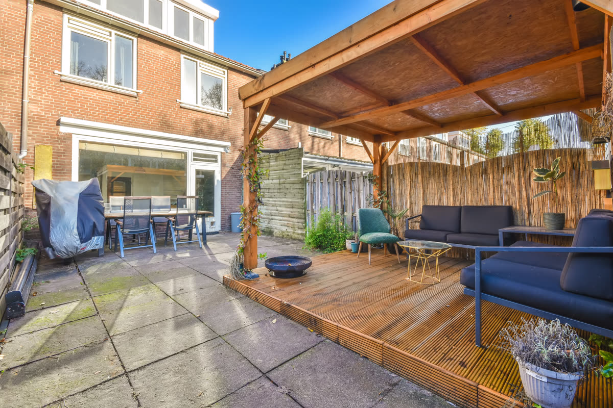 Deck with blue cushioned seating beside a paved courtyard