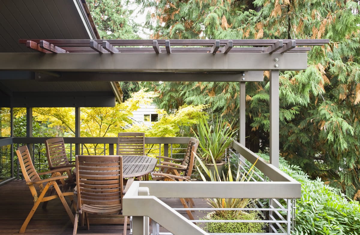 Timber deck with folding chairs overlooking a planted garden