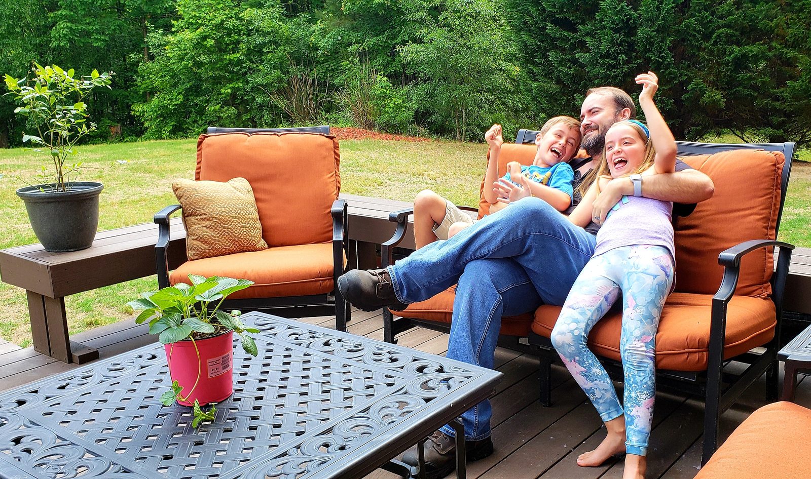 Family relaxing and laughing together on a backyard patio