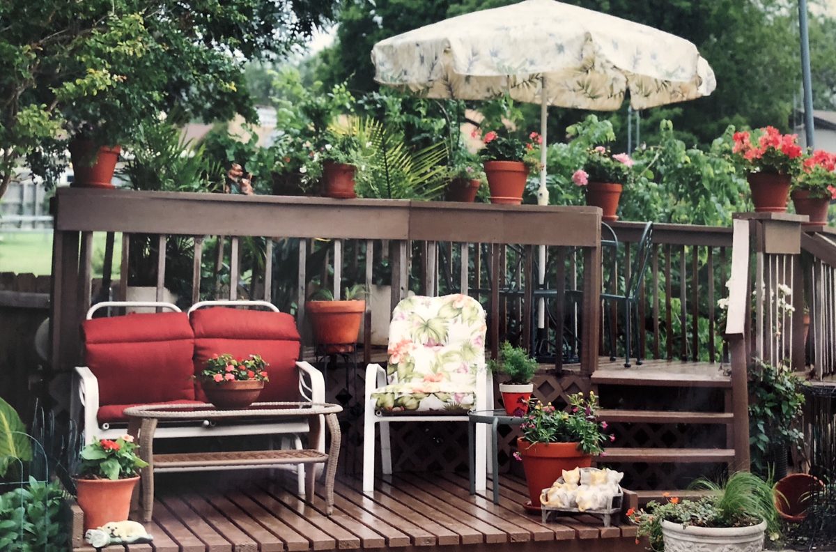Timber deck with blooming flowers and potted plants along the railing