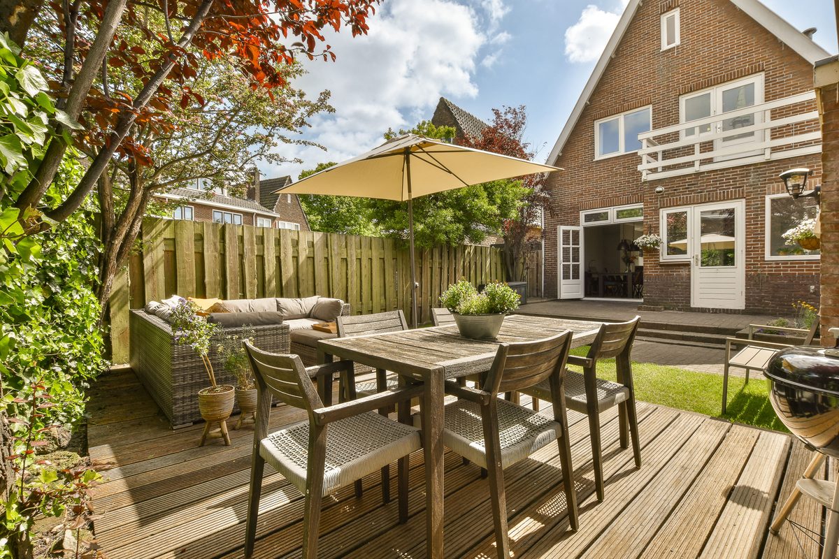 Backyard patio with a dining table under a wide umbrella