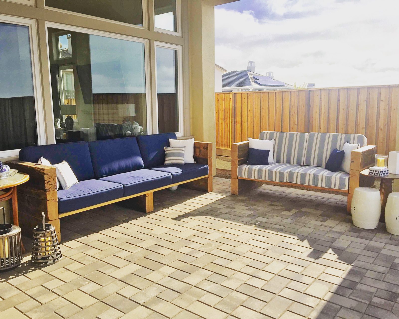 Upholstered sofas on a brick paver patio with a drainage grate in the paving