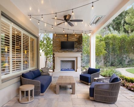 Covered outdoor living area with a ceiling fan keeping the air moving over seating
