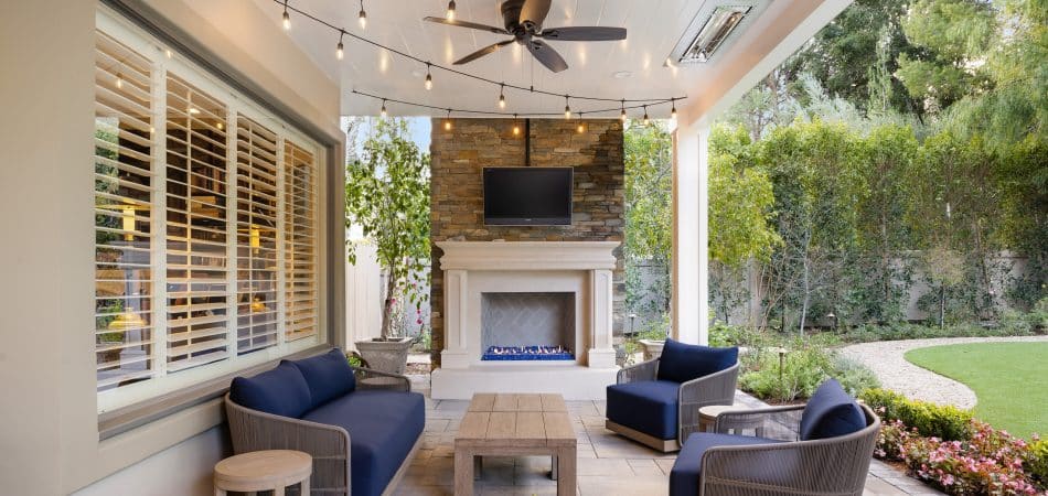Covered outdoor living area with a ceiling fan keeping the air moving over seating