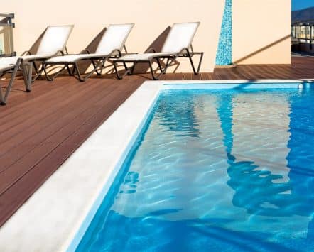 Swimming pool edged by a composite deck with lounge chairs